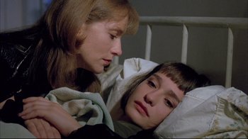 A young girl laying in bed with her mother