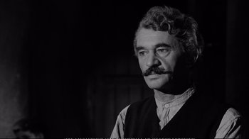 Movie still from “America America” (1963), directed by Elia Kazan – A man with curly hair wearing a vest and a mustache; Close Up shot, Over the shoulder angle