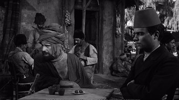 Movie still from “America America” (1963), directed by Elia Kazan – A group of men sitting around a table; Medium shot, Over the shoulder angle