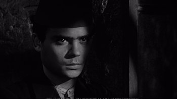 Movie still from “America America” (1963), directed by Elia Kazan – A black and white photo of a man in a suit and hat; Close Up shot, Over the shoulder angle