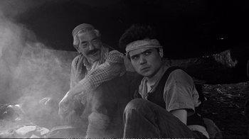 Movie still from “America America” (1963), directed by Elia Kazan – A man and an old man sitting next to each other; Medium shot, High angle