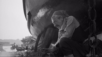 Movie still from “America America” (1963), directed by Elia Kazan – An older man working on a boat in a harbor; Medium shot, Low angle