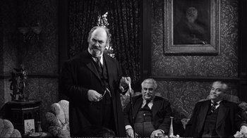 Movie still from “America America” (1963), directed by Elia Kazan – A man in a suit and tie standing next to another man in a suit and tie; Medium shot, Over the shoulder angle