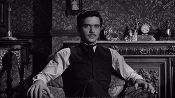 Movie still from “America America” (1963), directed by Elia Kazan – A black and white photo of a man sitting in a chair; Medium shot, High angle