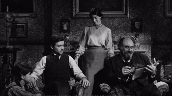 Movie still from “America America” (1963), directed by Elia Kazan – An old photo of a woman and two men sitting on a couch; Medium shot, High angle