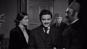 Movie still from “America America” (1963), directed by Elia Kazan – A group of men and women standing next to each other in a room; Medium shot, Over the shoulder angle