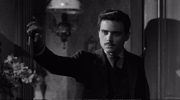 Movie still from “America America” (1963), directed by Elia Kazan – A black and white photo of a man in a suit and tie; Medium shot, Over the shoulder angle
