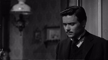 Movie still from “America America” (1963), directed by Elia Kazan – A black and white photo of a man in a suit and tie; Close Up shot, Over the shoulder angle