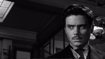 Movie still from “America America” (1963), directed by Elia Kazan – A black and white photo of a man in a suit and tie; Close Up shot, Over the shoulder angle