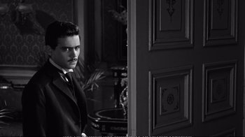 Movie still from “America America” (1963), directed by Elia Kazan – A black and white photo of a man standing in front of an open door; Medium shot, Over the shoulder angle