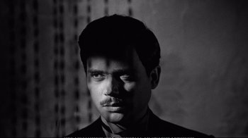 Movie still from “America America” (1963), directed by Elia Kazan – A black and white photo of a man in a suit; Close Up shot, High angle