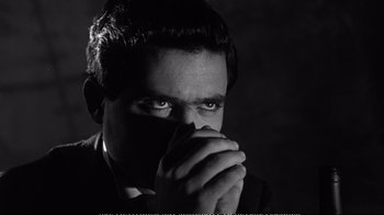 Movie still from “America America” (1963), directed by Elia Kazan – A black and white photo of a man in a suit; Close Up shot, High angle