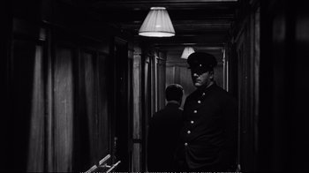 Movie still from “America America” (1963), directed by Elia Kazan – A black and white photo of a man in a uniform in a hallway; Medium shot, Low angle