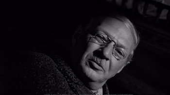 Movie still from “America America” (1963), directed by Elia Kazan – An older man wearing glasses and a sweater; Close Up shot, Over the shoulder angle