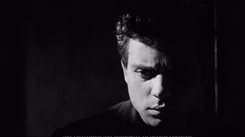 Movie still from “America America” (1963), directed by Elia Kazan – Black and white photograph of a young man with a serious look; Close Up shot, Low angle