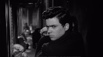 Movie still from “America America” (1963), directed by Elia Kazan – Black and white photograph of a young man in a sweater; Close Up shot, Over the shoulder angle