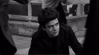 Movie still from “America America” (1963), directed by Elia Kazan – Black and white photograph of a young man sitting on steps; Close Up shot, High angle