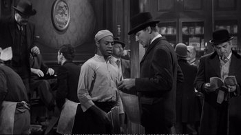 Movie still from “America America” (1963), directed by Elia Kazan – A man in a hat is talking to another man in a hat; Medium shot, Over the shoulder angle