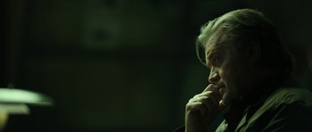 Movie still from “American Dharma” (2018), directed by Errol Morris – An older man is sitting in a dark room; Close Up shot, Low angle