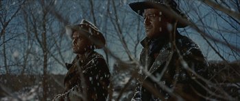 Movie still from “American Dharma” (2018), directed by Errol Morris – A couple of men standing next to each other in the snow; Medium shot, Low angle