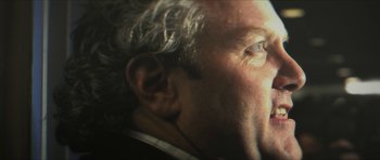 Movie still from “American Dharma” (2018), directed by Errol Morris – An older man with white hair is looking into the distance; Extreme Close Up shot, Low angle