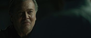 Movie still from “American Dharma” (2018), directed by Errol Morris – An older man is looking at the camera; Close Up shot, Over the shoulder angle