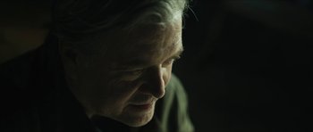 Movie still from “American Dharma” (2018), directed by Errol Morris – An older man with white hair looking down at the ground; Close Up shot, Over the shoulder angle