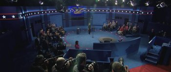 Movie still from “American Dharma” (2018), directed by Errol Morris – A crowd of people sitting in a room with microphones; Extreme Wide shot, High angle