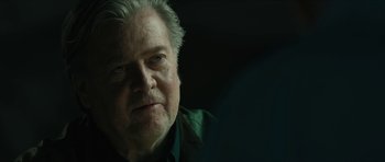 Movie still from “American Dharma” (2018), directed by Errol Morris – An older man with white hair is looking at the camera; Close Up shot, Over the shoulder angle