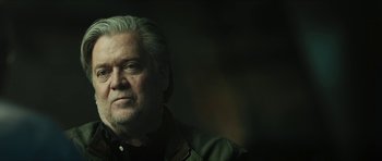 Movie still from “American Dharma” (2018), directed by Errol Morris – An older man with white hair looking at the camera; Close Up shot, Low angle