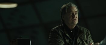 Movie still from “American Dharma” (2018), directed by Errol Morris – An older man sitting in front of a wall; Close Up shot, Low angle