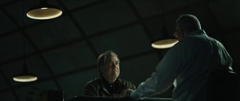 Movie still from “American Dharma” (2018), directed by Errol Morris – An older man holding a frisbee in front of him; Medium shot, Over the shoulder angle