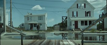 Movie still from “American Dharma” (2018), directed by Errol Morris – A man walking down the street in front of some houses; Extreme Wide shot, Low angle