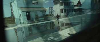 Movie still from “American Dharma” (2018), directed by Errol Morris – A man walking down the street in a flooded area; Wide shot, High angle