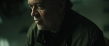 Movie still from “American Dharma” (2018), directed by Errol Morris – An older man with a goatee looking to his left; Close Up shot, Over the shoulder angle