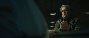 Movie still from “American Dharma” (2018), directed by Errol Morris – A man sitting in front of a mirror holding a cell phone to his ear; Close Up shot, Over the shoulder angle