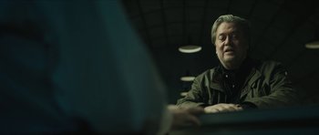 Movie still from “American Dharma” (2018), directed by Errol Morris – A man sitting in front of a computer keyboard; Medium shot, Over the shoulder angle