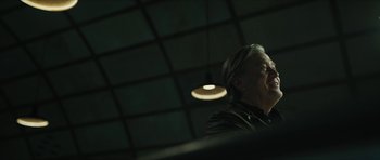 Movie still from “American Dharma” (2018), directed by Errol Morris – An older man is looking up at the ceiling lights; Close Up shot, Low angle