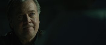 Movie still from “American Dharma” (2018), directed by Errol Morris – An older man is smiling for the camera; Close Up shot, Over the shoulder angle