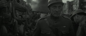Movie still from “American Dharma” (2018), directed by Errol Morris – A man in a military uniform standing in front of a pile of dirt; Close Up shot, Low angle