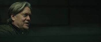 Movie still from “American Dharma” (2018), directed by Errol Morris – A man with blonde hair standing in front of a window; Close Up shot, Over the shoulder angle