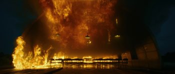 Movie still from “American Dharma” (2018), directed by Errol Morris – A fire is burning in the sky over a lake; Extreme Wide shot, High angle