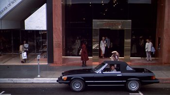 Movie still from “American Gigolo” (1980), directed by Paul Schrader – A car parked on the side of the road near a building; Extreme Wide shot, High angle