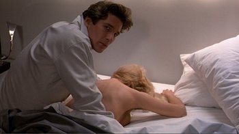 Movie still from “American Gigolo” (1980), directed by Paul Schrader – A man and a woman laying in a bed together; Medium shot, Over the shoulder angle