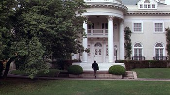 Movie still from “American Gigolo” (1980), directed by Paul Schrader – A person walking in front of a large white house; Extreme Wide shot, Low angle