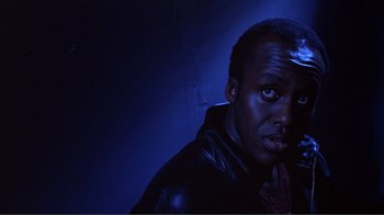 Movie still from “American Gigolo” (1980), directed by Paul Schrader – A man in a black jacket is in a dark room; Close Up shot, Low angle