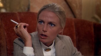 Movie still from “American Gigolo” (1980), directed by Paul Schrader – A woman in a suit is sitting on a couch; Close Up shot, Over the shoulder angle