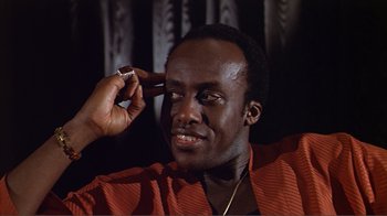 Movie still from “American Gigolo” (1980), directed by Paul Schrader – A man is holding a cell phone up to his ear; Close Up shot, Low angle