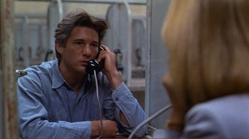Movie still from “American Gigolo” (1980), directed by Paul Schrader – A man talking on a phone in front of a mirror; Close Up shot, Over the shoulder angle