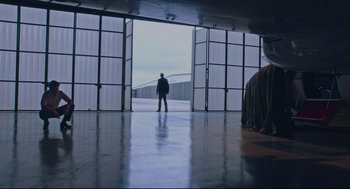 Movie still from “American Made” (2017), directed by Doug Liman – A man standing in front of an open garage door; Wide shot, Low angle
